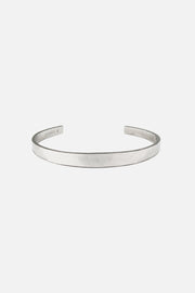 Silver-tone narrow flat cuff bracelet, front view on a light background