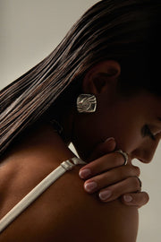 Model with her head lowered wearing the square stud