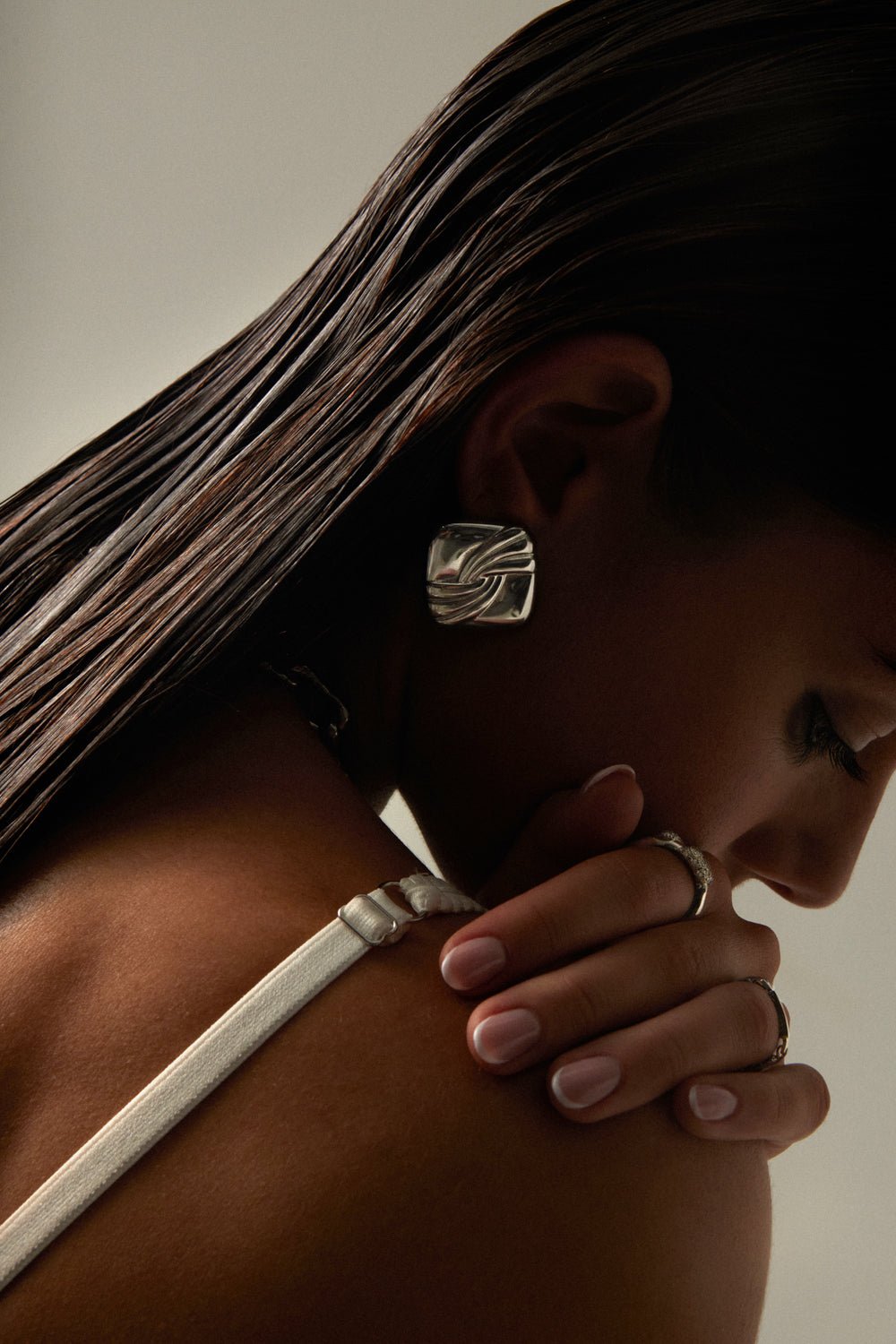 Model with her head lowered wearing the square stud