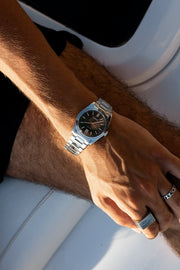 Wrist on a white boat seat wearing the watch