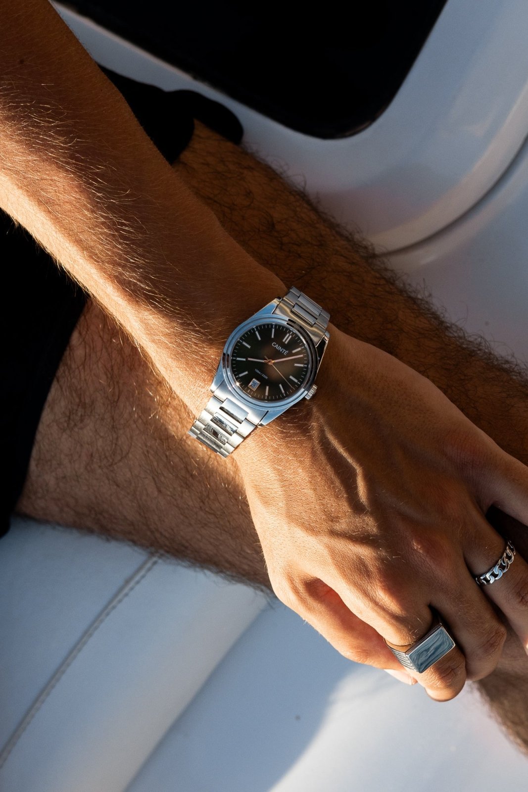 Wrist on a white boat seat wearing the watch