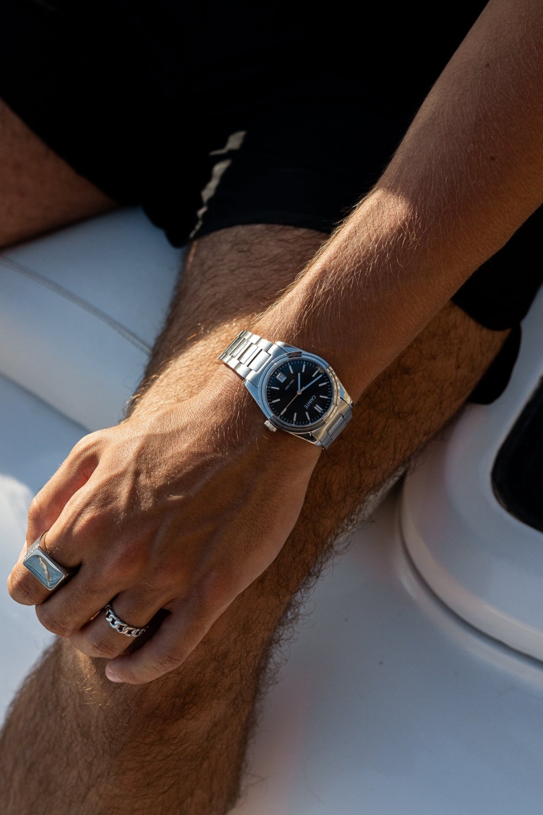 Wrist on a white boat seat wearing the watch