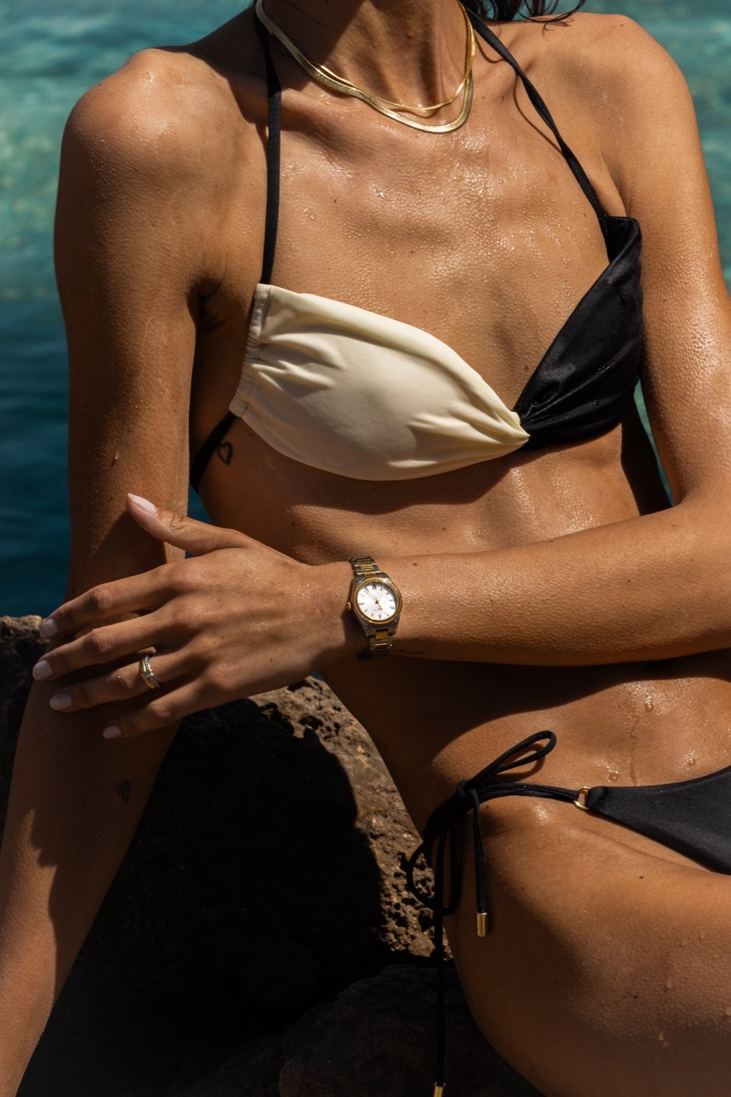 Woman sitting on rocks wearing the round watch