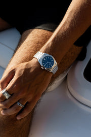 Wrist on a white boat seat wearing the watch