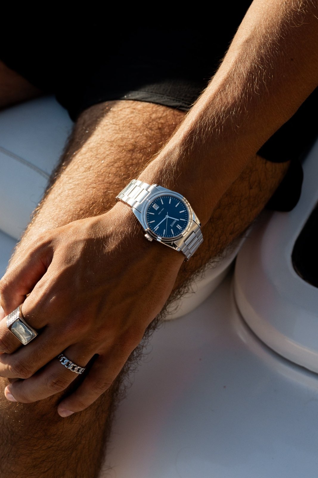 Wrist on a white boat seat wearing the watch