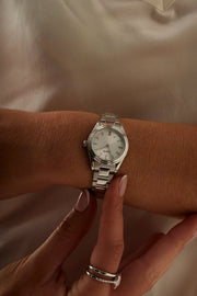 Hands adjusting the small round watch
