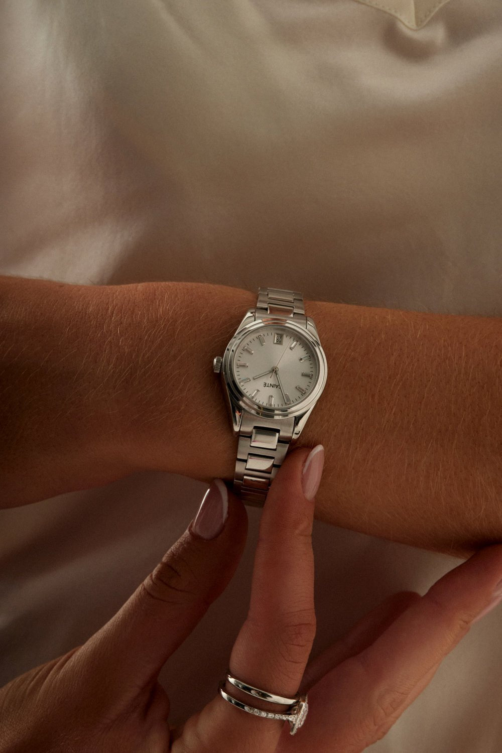 Hands adjusting the small round watch