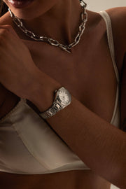 Wrist and chain necklace with the watch visible