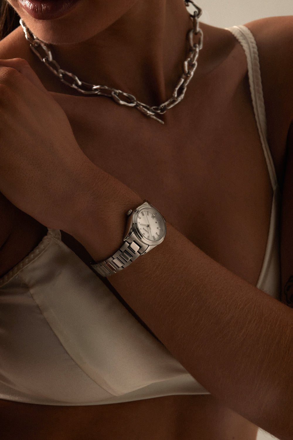 Wrist and chain necklace with the watch visible