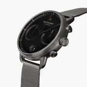 Angled view of the black dial with two subdials, pushers and the gunmetal case.