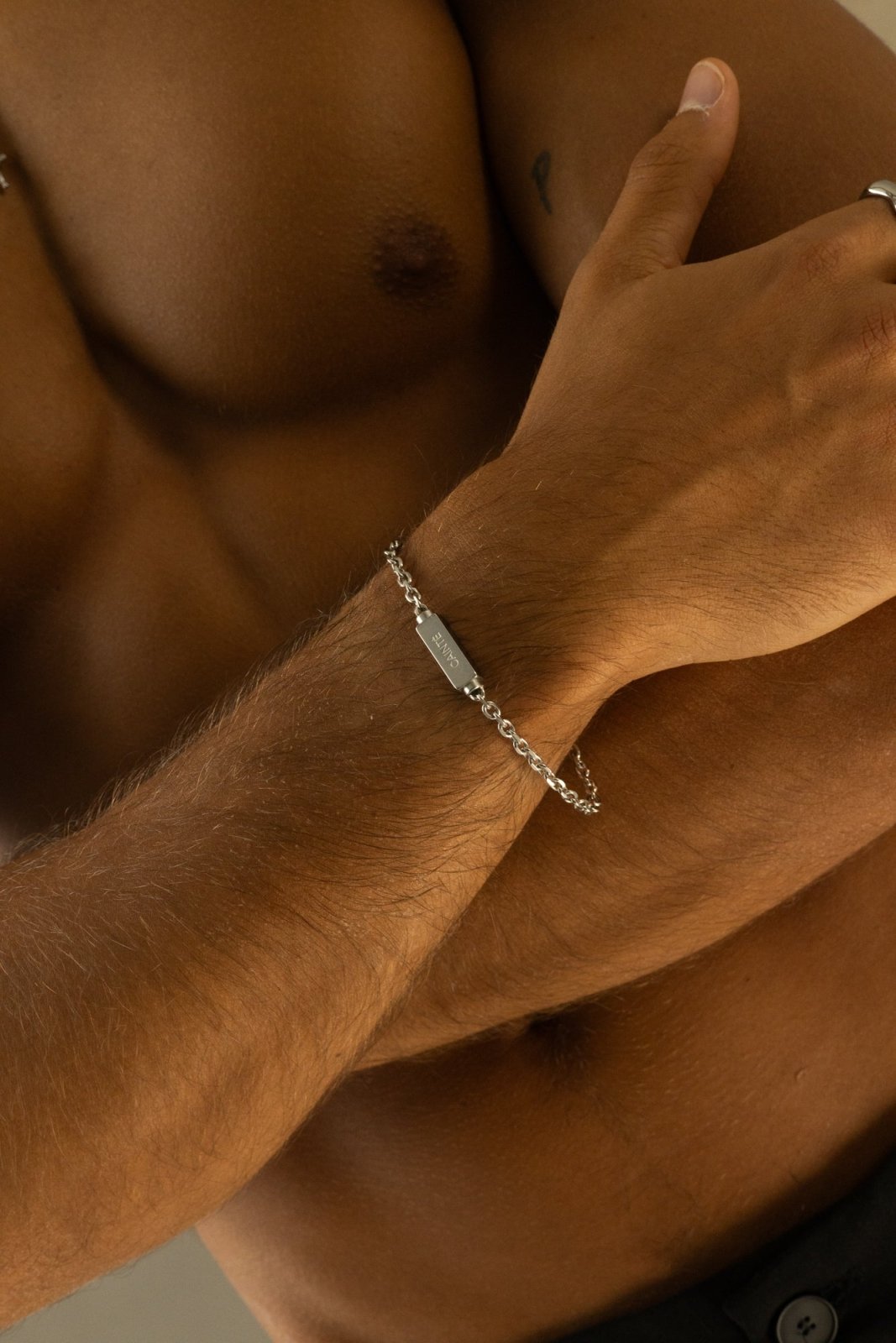 Silver-tone chain bracelet worn with arms folded