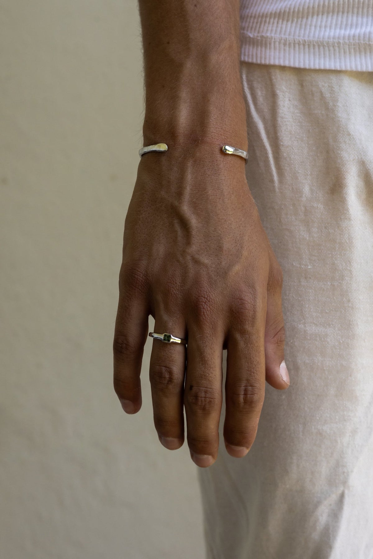 Man wearing the green stone ring with a cuff bracelet