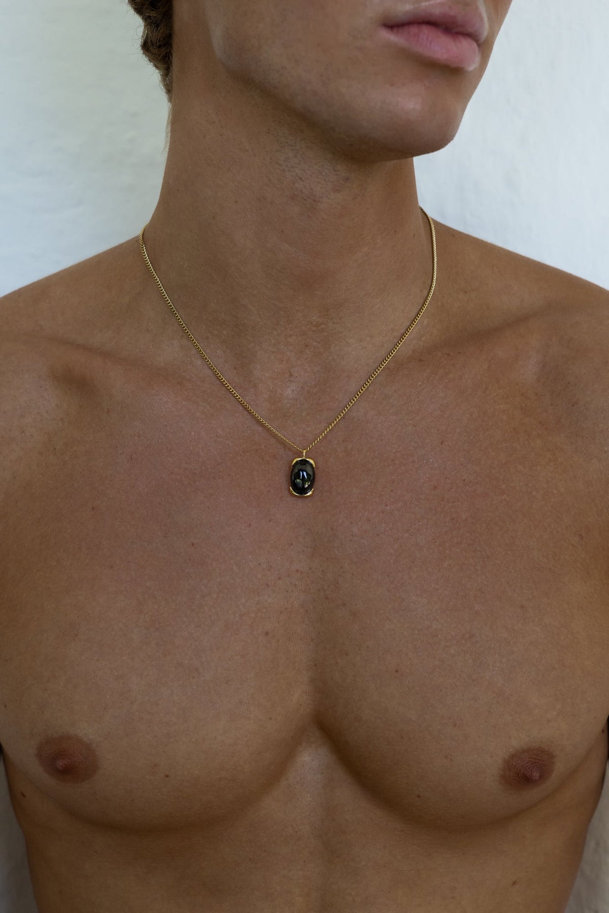 Gold-tone necklace with a black oval pendant, view 2 of 7