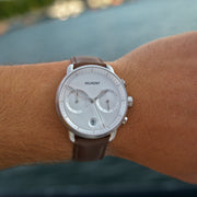 Worn outdoors on a wrist against a blurred blue background.