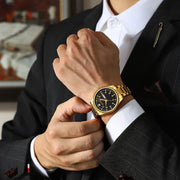 Gold-tone watch adjusted at a shirt cuff