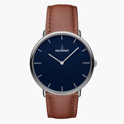 Watch with a blue sunburst dial and silver-tone case on a brown strap, shown from the front.