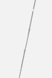 Detail of the fine silver-tone curb chain with small bar details