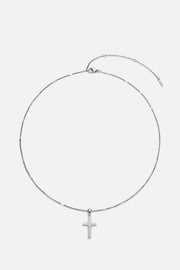 Silver-tone cross necklace laid flat with extender chain