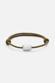 Brown cord bracelet with a white bead, front view on a light background