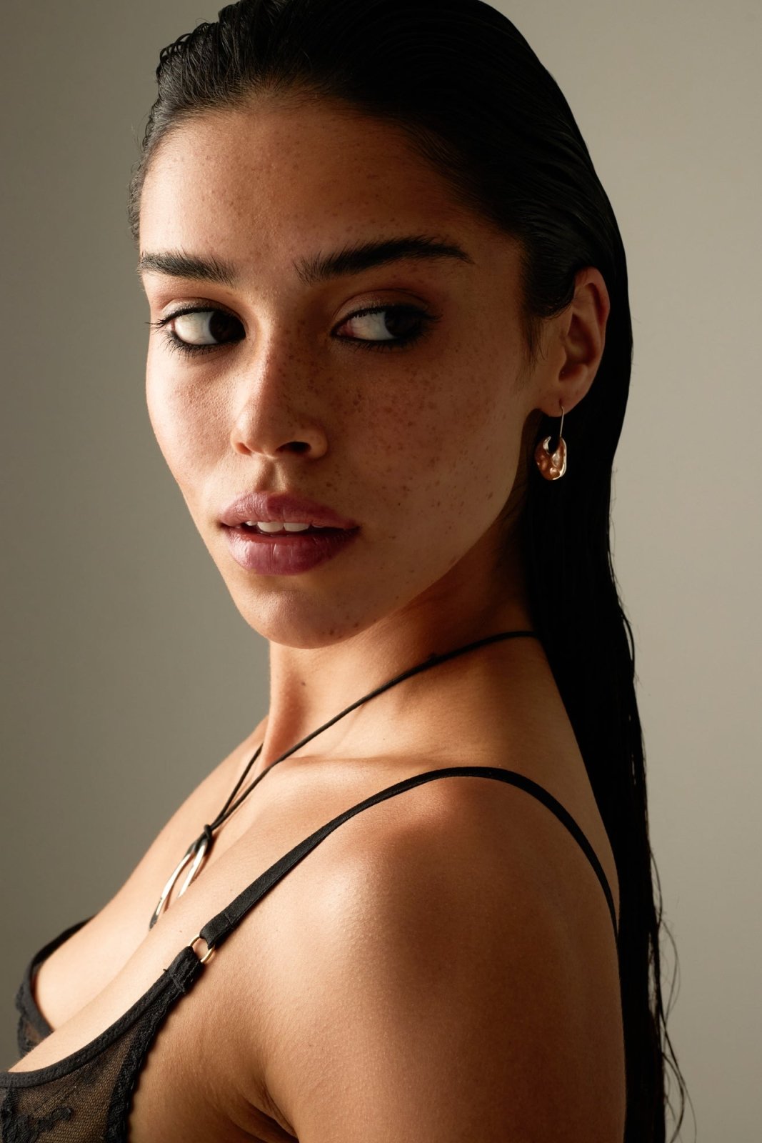 Model looking over her shoulder wearing the drop earring