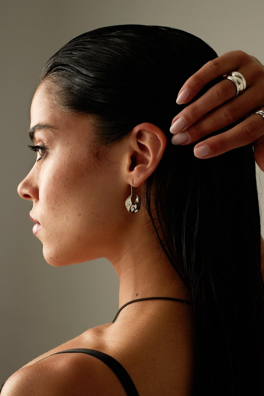 Model in profile wearing the hammered drop earring