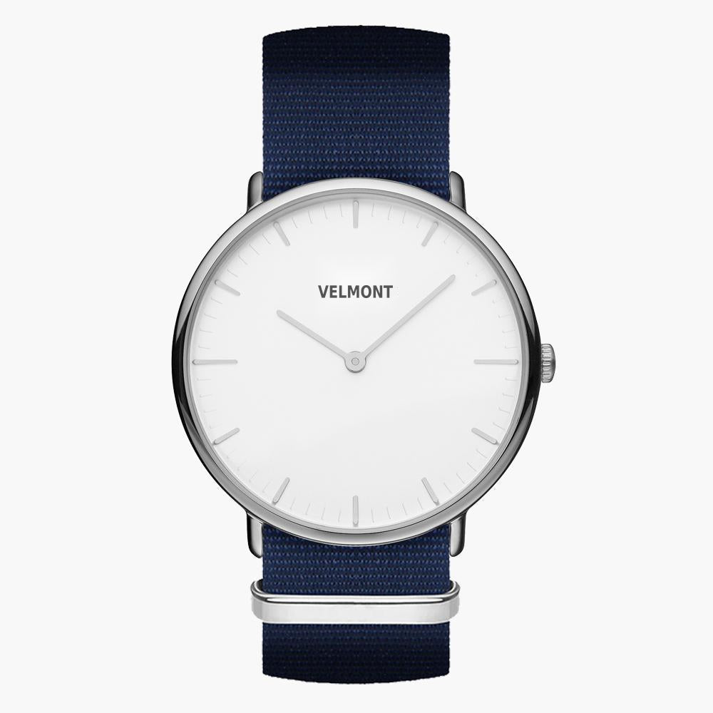 Minimalist watch with a white dial and silver-tone case on a navy woven strap.