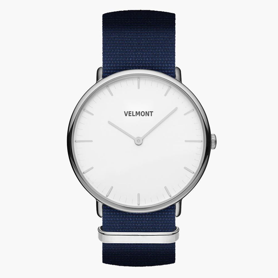 Minimalist watch with a white dial and silver-tone case on a navy woven strap.