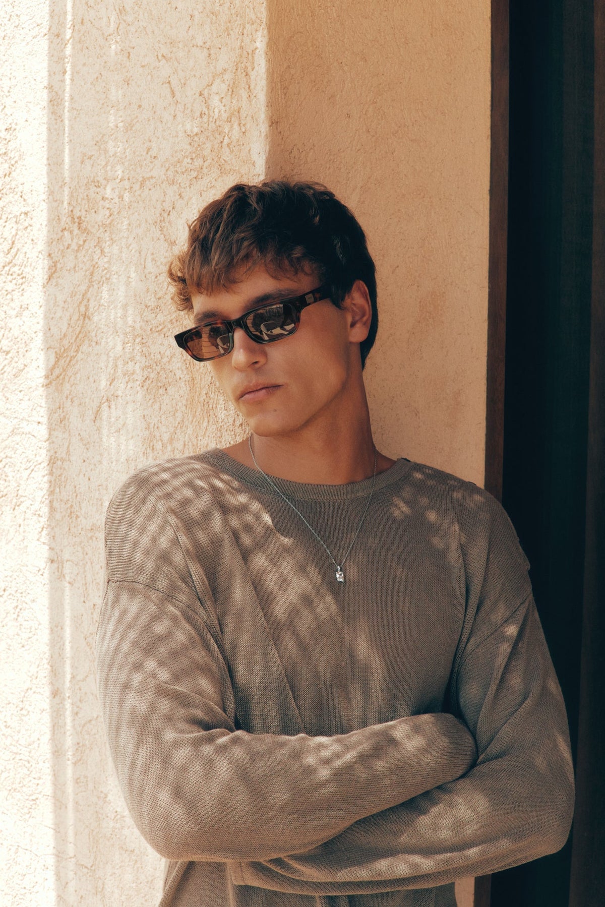 Man with arms crossed wearing the sunglasses