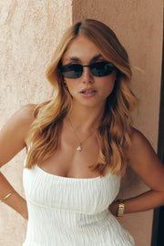 Woman wearing the thin black sunglasses, front view