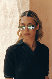 Woman in a black knit top wearing the mirrored sunglasses