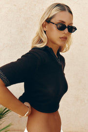 Woman in a black knit top wearing the sunglasses