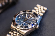 Blue dial watch on a blue surface