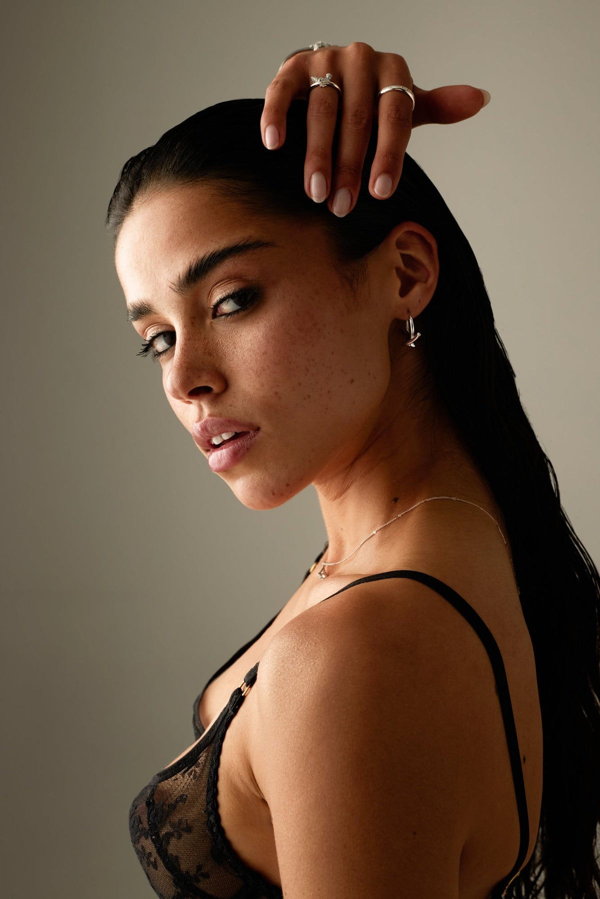 Model with her hand on her head wearing the hoops