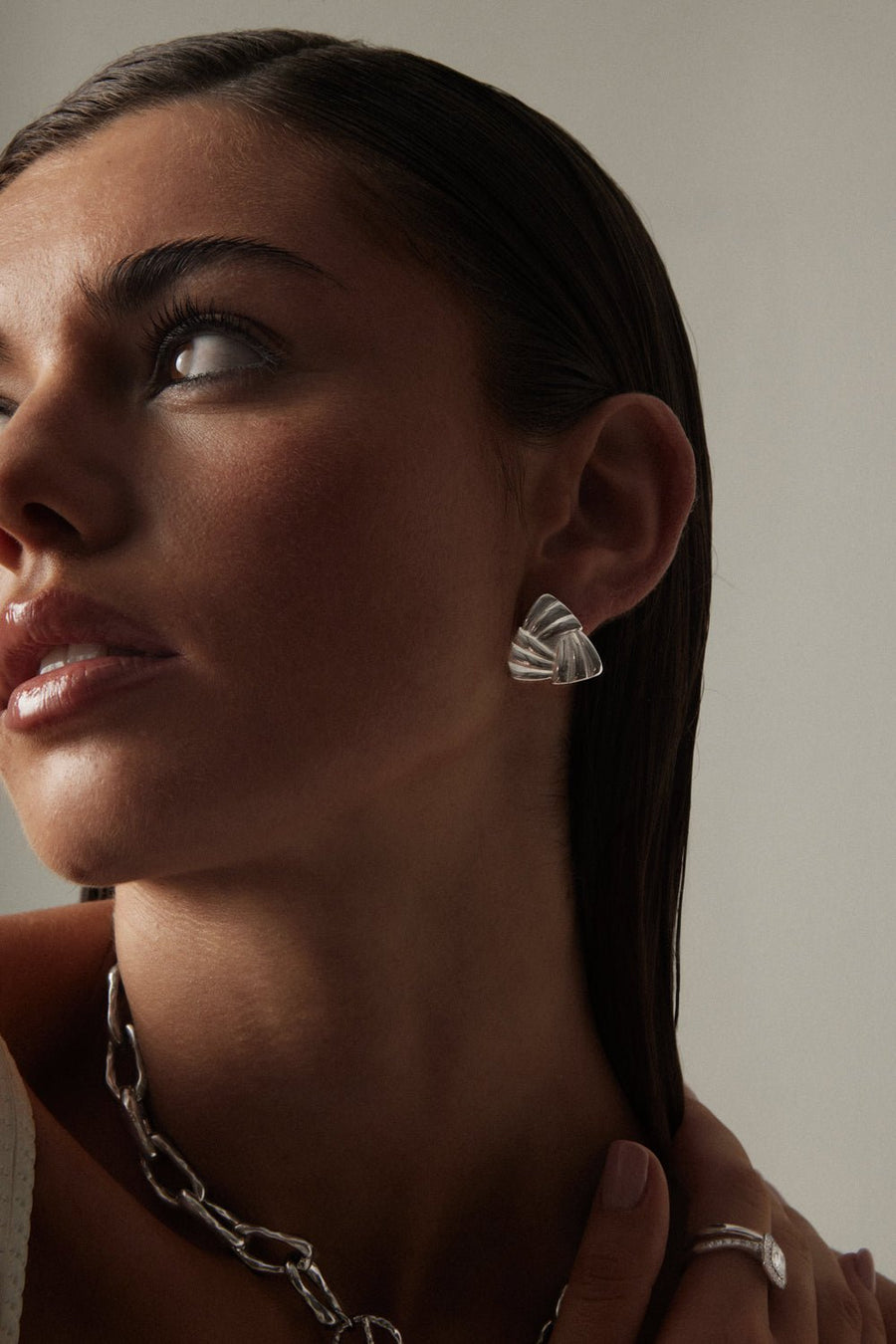 Model looking up wearing the triangle stud