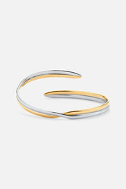 Two-tone crossover cuff bracelet, front view on a light background