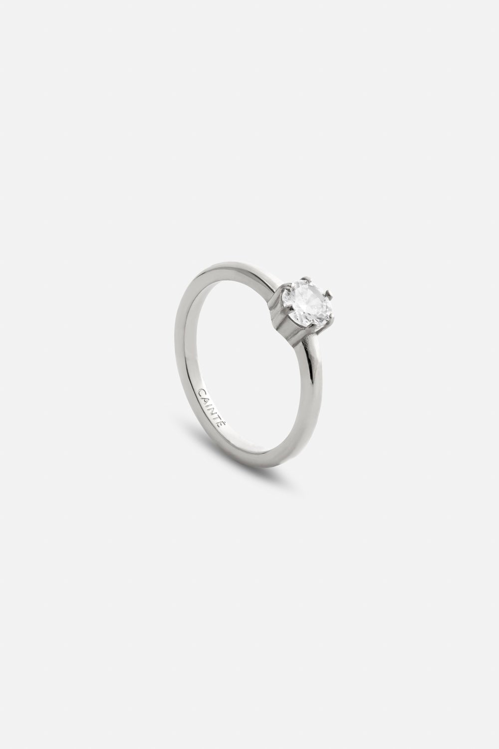 Silver-tone solitaire ring with a clear stone, front view on a light background