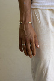 Man in linen trousers wearing the thin band ring