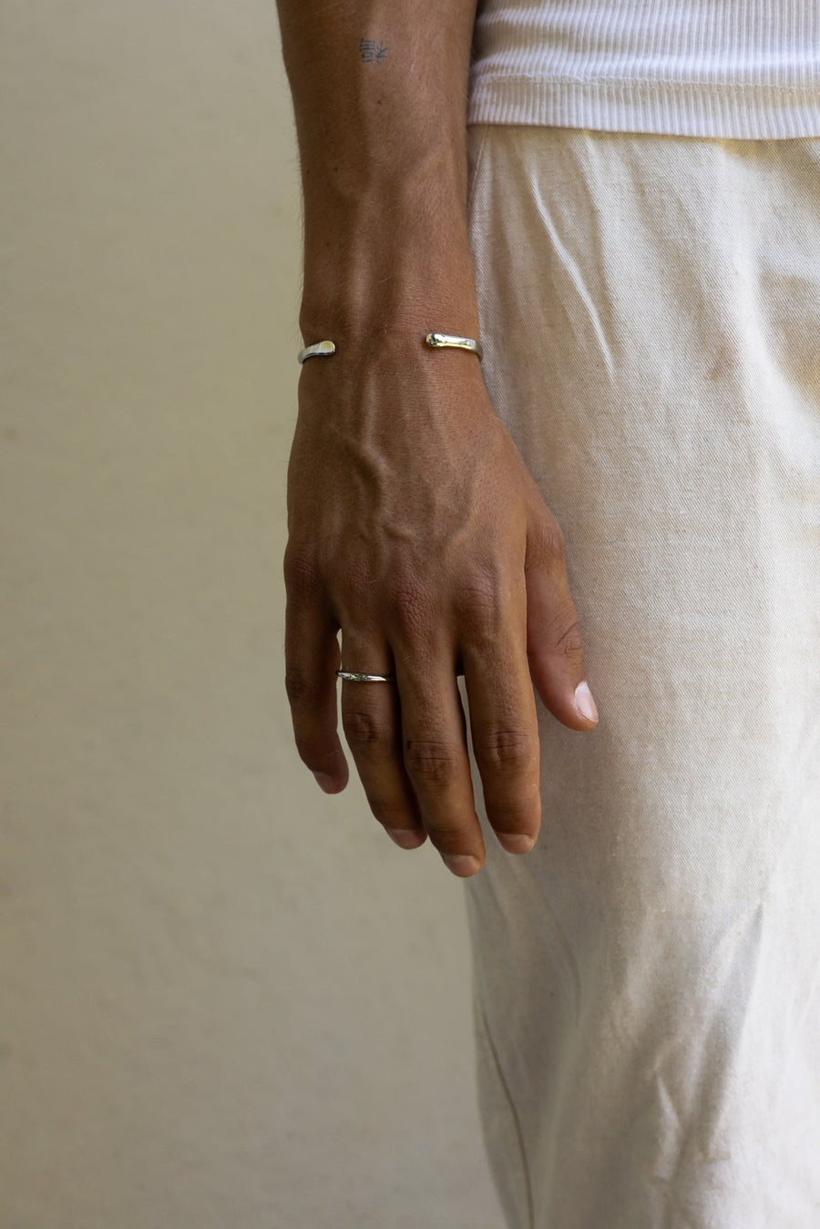 Man in linen trousers wearing the thin band ring