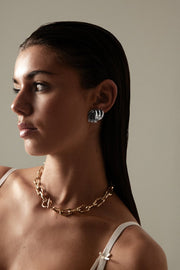 Model in profile wearing the stud and a chain necklace