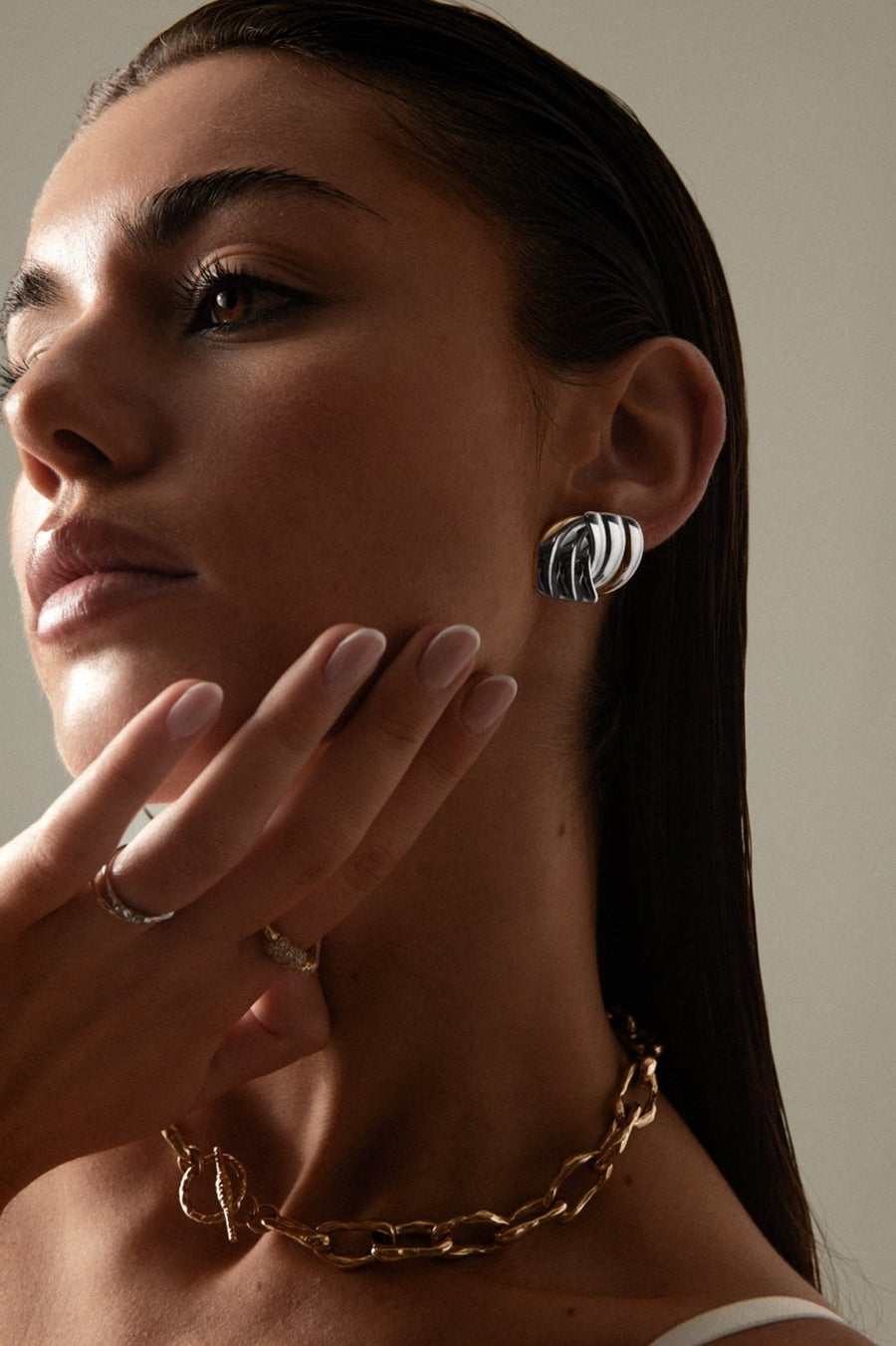 Model touching her chin, wearing the chunky stud