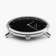 Slim silver-tone case from the side with the black dial showing.
