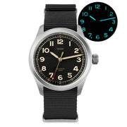 Black-dial field watch on a black nylon strap with glow-in-the-dark inset